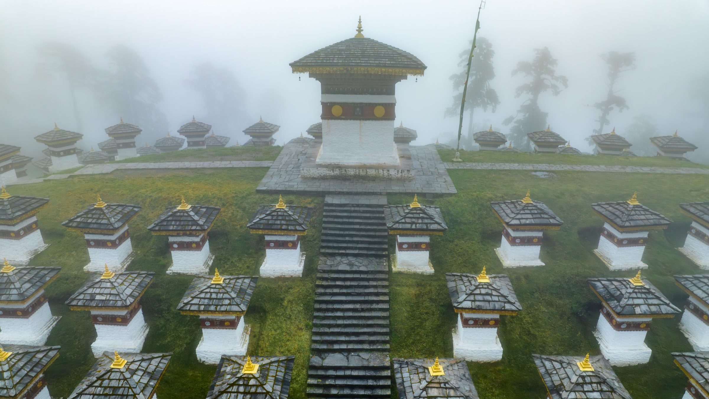The Druk Wangyal stupa and the 108 memorial chortens in mist at Dochula Pass